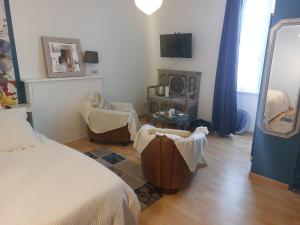 a bedroom with a bed and a chair and a mirror at L'Eclose Chambre Ildut in Le Guilvinec