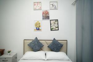 a bedroom with a bed with pillows and pictures on the wall at Cozy Studio Netflix Parking Self Checkin Wifi free wifi 138 in Cyberjaya +38 photos