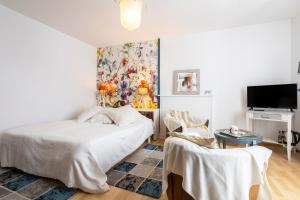 a bedroom with a bed and a painting on the wall at L'Eclose Chambre Ildut in Le Guilvinec