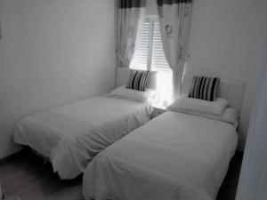two beds in a small room with a window at Duquesa Beach in Torrevieja +37 photos