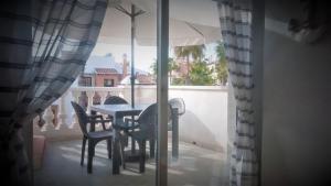 a table and chairs on a balcony with an umbrella at Duquesa Beach in Torrevieja
