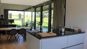 a kitchen with a counter with a table and chairs at Ferienhaus Wreechen 25, Haus 1 in Putbus