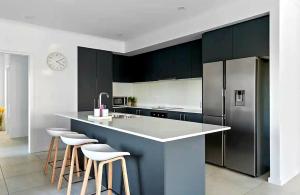 a kitchen with black cabinets and a counter with stools at Surfside Getaway Caves Beach Absolute Beachfront in Caves Beach +41 photos