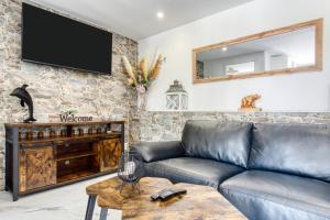 a living room with a leather couch and a tv at Park Carpe Diem in Busot