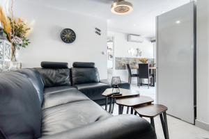 a living room with a black leather couch and tables at Park Carpe Diem in Busot