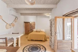 a bedroom with a bed and a table and a door at Can Xicu in Illes Balears