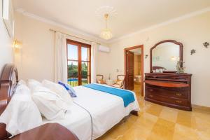 ein Schlafzimmer mit einem Bett, einer Kommode und einem Spiegel in der Unterkunft Finca Llum in Islas Baleares + 26 Fotos