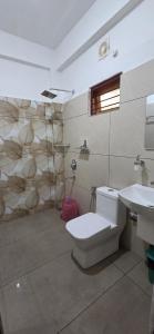 a bathroom with a toilet and a sink at Periyar Inn in Thekkady +63 photos