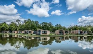 a row of modular homes next to a lake at Summio Vakantiepark Schaijk in Schayk