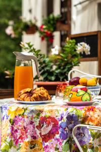 a table with a plate of food and orange juice at B&B Paradiso in Gubbio