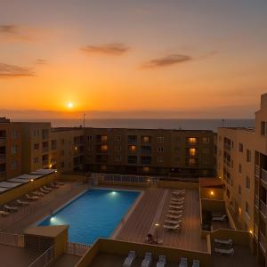 a pool on the roof of a building with a sunset at Apartamento Erma Candelaria in Candelaria