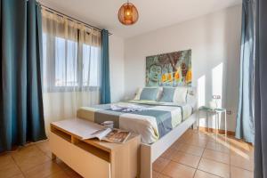 a bedroom with a king sized bed with blue curtains at Vanilla Ocean Chalet in Majanicho +24 photos