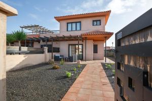 a house with a pathway in front of it at Vanilla Ocean Chalet in Majanicho