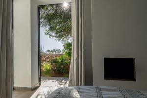 a bedroom with a bed and a window with a view at Villa Celeste-Essaouira, piscine chauffée, vue sur la campagne in Essaouira