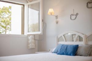 a bedroom with a white bed and a window at El Faro 8 in Cala en Bosc