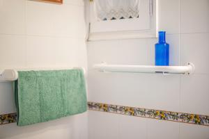 a bathroom with a green towel and a blue bottle at El Faro 8 in Cala en Bosc +17 photos