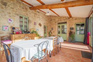a kitchen with a table and chairs in a room at Perles De Aime in Laurac-en-Vivarais