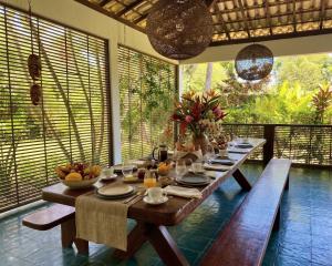 a dining room with a long table with food on it at AZORAI - Hotel Boutique in Santa Cruz Cabrália