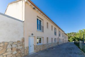 a building with a stone wall next to a street at Las Gargantas de Gredos in Burgohondo