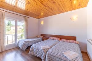 a bedroom with two beds and a large window at Las Gargantas de Gredos in Burgohondo +32 photos