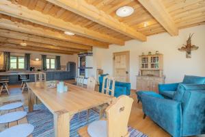 a dining room and kitchen with a wooden table and chairs at Englburger Hof in Tittling