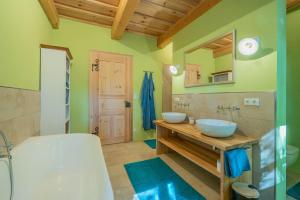 a bathroom with two sinks and a tub and a mirror at Englburger Hof in Tittling +29 photos