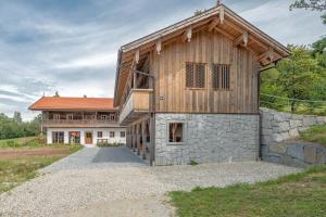 a barn style house with a stone wall at Englburger Hof in Tittling