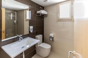 a bathroom with a sink and a toilet and a mirror at Hotel L'Anxana - Sólo Adultos in Formiche Alto