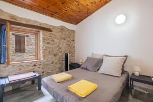 a bedroom with a large bed with yellow towels on it at Au Petit Paris, Centre de Céret in Céret