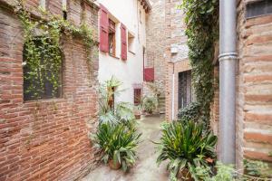 an alley in an old building with plants at Au Petit Paris, Centre de Céret in Céret