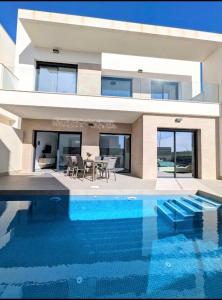 a house with a swimming pool in front of a house at R-53 Corner Villa with private pool in Los Montesinos