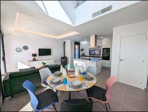 a dining room and living room with a table and chairs at R-53 Corner Villa with private pool in Los Montesinos