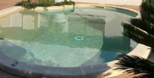 an empty swimming pool with a pool noodle in the water at Ô'wazo, Jolie Maison, Piscine in Lanton