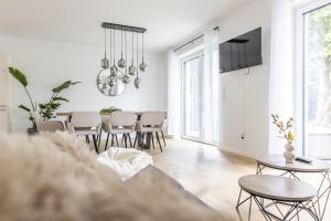 a white living room with a table and chairs at Das Strandhaus 2 in Lembruch