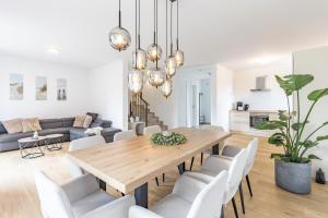 a dining room with a wooden table and chairs at Das Strandhaus 2 in Lembruch