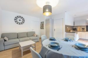 a living room with a table and a couch at Chalets De L'arriutort 1 - Laruns in Laruns