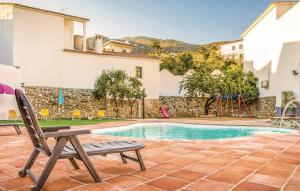 a chair next to a pool with a playground at Villa Godoy in Periana