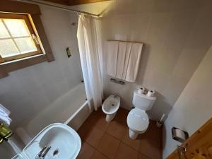 a white bathroom with a toilet and a sink at Chalet Belfort in Penhas da Saúde +19 photos