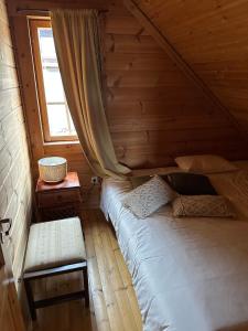 a bed in a wooden room with a window at Chalet Belfort in Penhas da Saúde