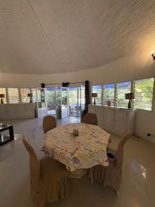 a dining room with a table and chairs and windows at Villa Maria in Cap Skirring