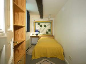 a small bedroom with a bed with a yellow blanket at Teichblick in Trebel