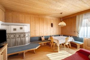 a dining room with a table and a tv at Hatzlhof Appartements in Vipiteno