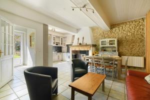 a kitchen and living room with a table and chairs at Gite De Marlas in Rieucros