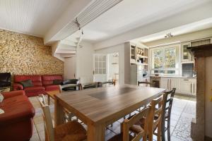 a kitchen and living room with a wooden table at Gite De Marlas in Rieucros +14 photos