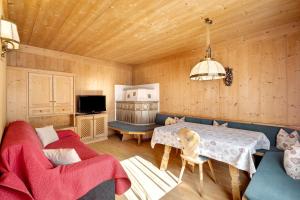 a living room with a table and a couch at Hatzlhof Appartements in Vipiteno