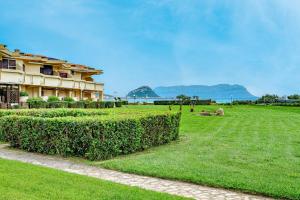a grassy field next to a building with a hedge at Casa Dina - by And Service in Golfo Aranci