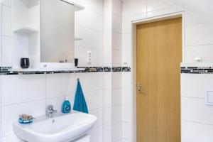 a white bathroom with a sink and a mirror at Fewo Wilhelmshaven Langewerth in Wilhelmshaven
