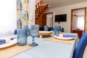 a dining room with a table with blue glasses on it at Central Square in Povoação