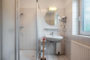 a bathroom with a sink and a shower at Sonne, Wind und Wetter in Wurster Nordseeküste +21 photos