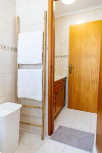 a bathroom with a sink and a wooden door at Central Square in Povoação +47 photos